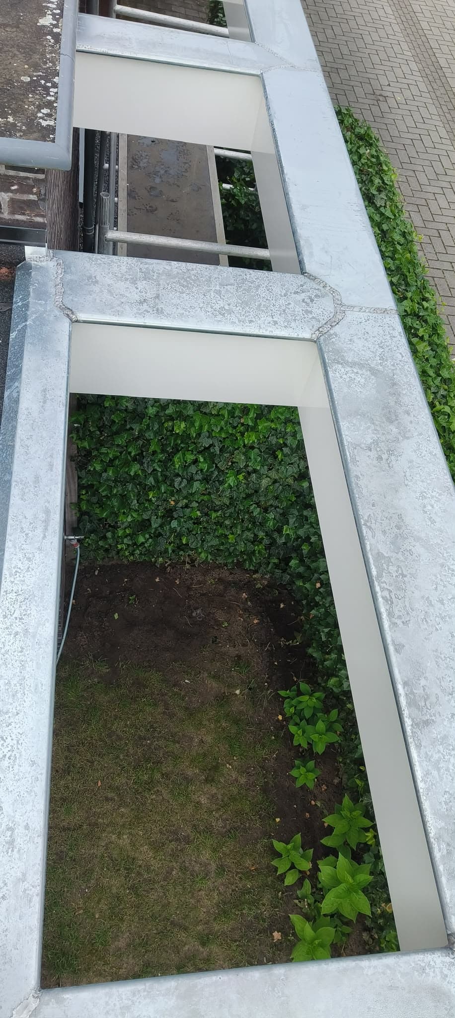 Zinkbeklede liggers van een tuinoverkapping, van bovenaf gezien